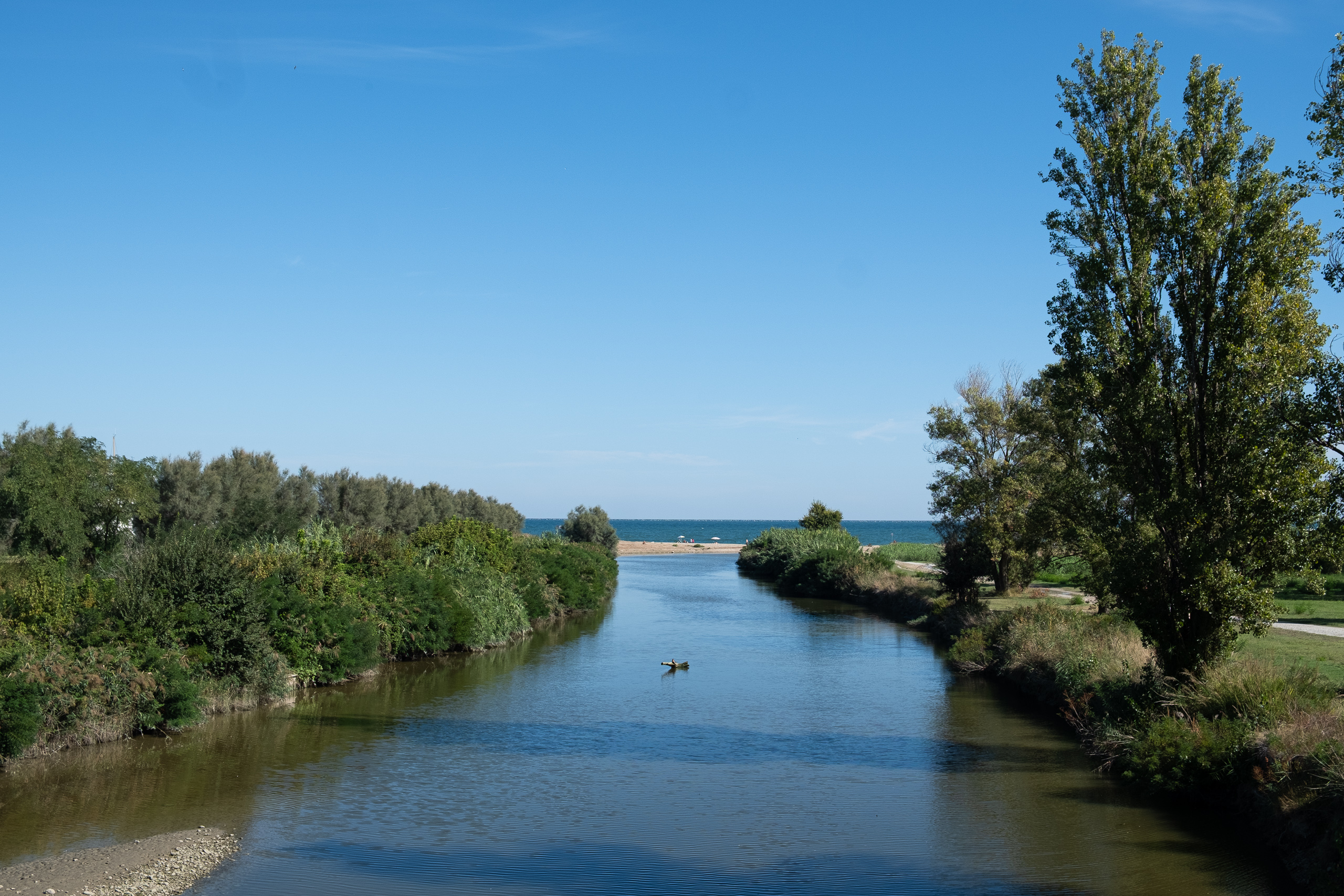 Kleiner Fluss mündet ins Meer – Strand am Horizont